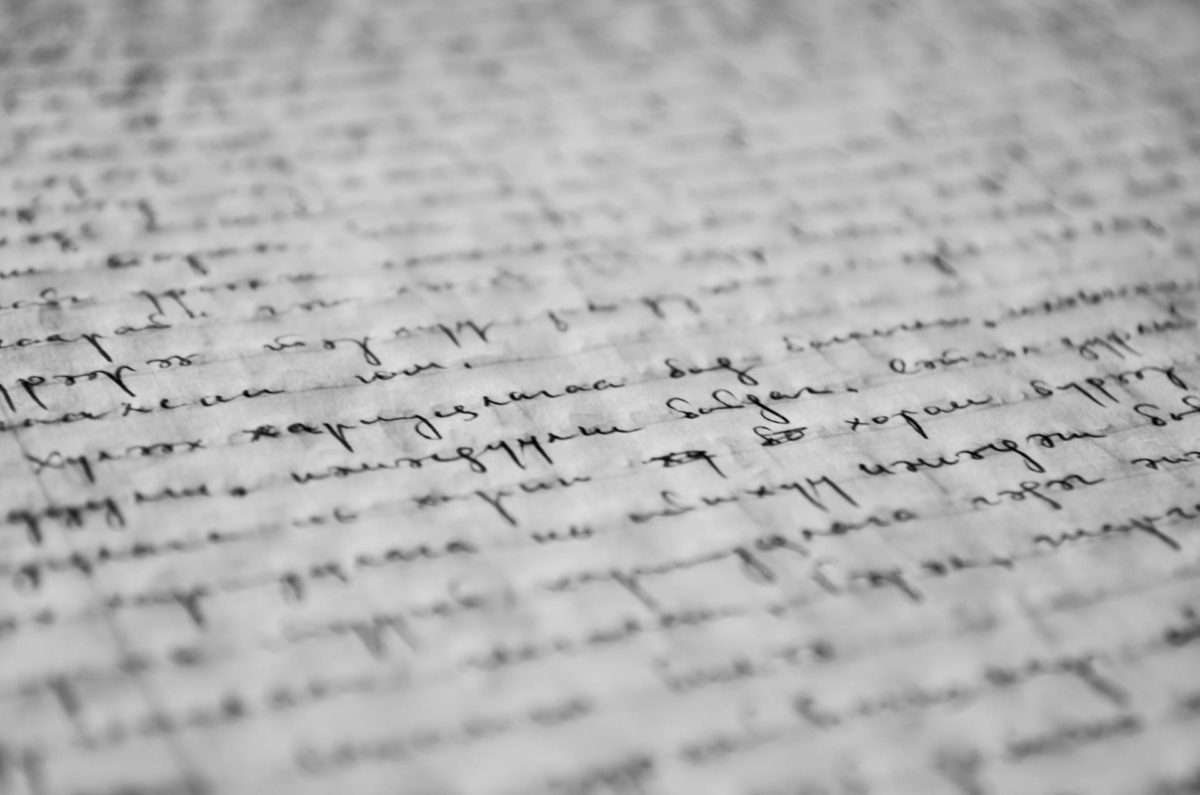 Angular close-up of a white piece of paper, handwritten on in regal style with black ink—depicting the writings of one who has decided to give up on everything and drop out of society.
